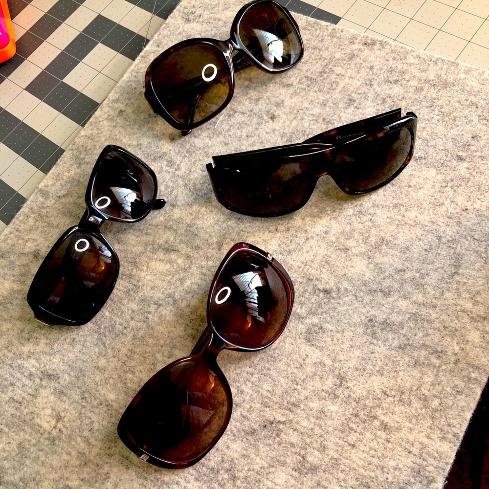 Four pairs of sunglasses.  Fendi, Burberry, Gucci and Kate Spade